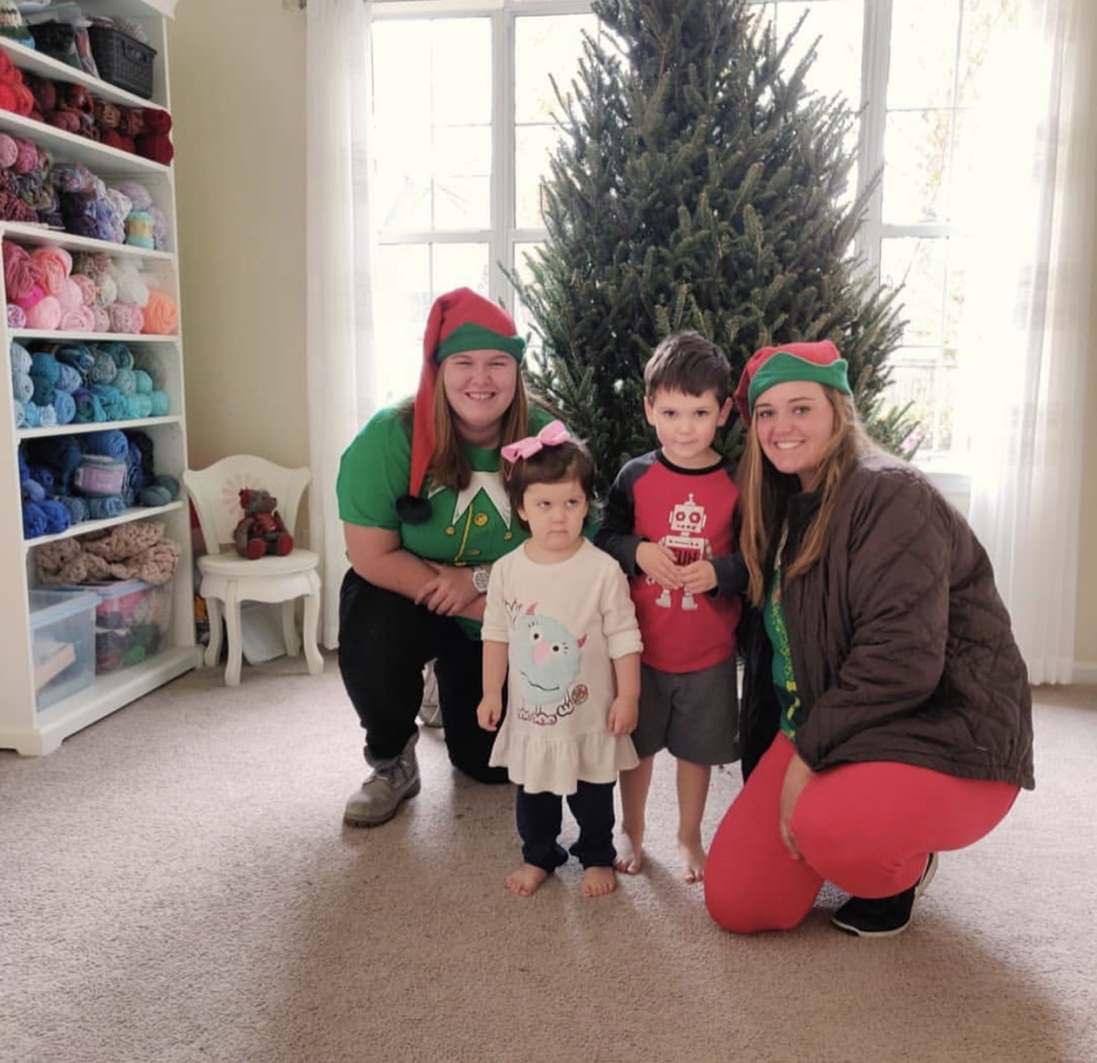 A Fraser fir in a bright playroom, with the elves and two kids
