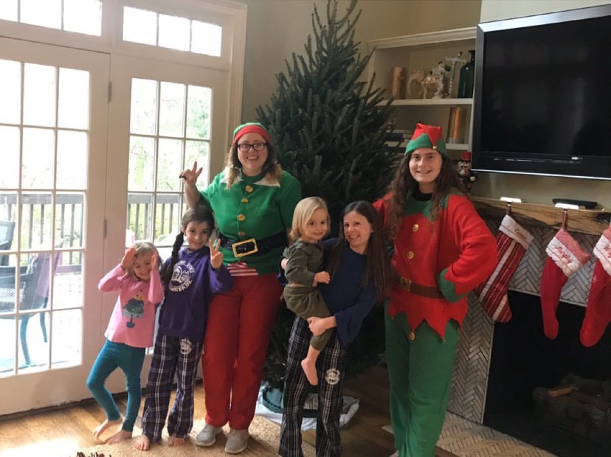 A full Fraser fir by the fireplace, with the elves and a family