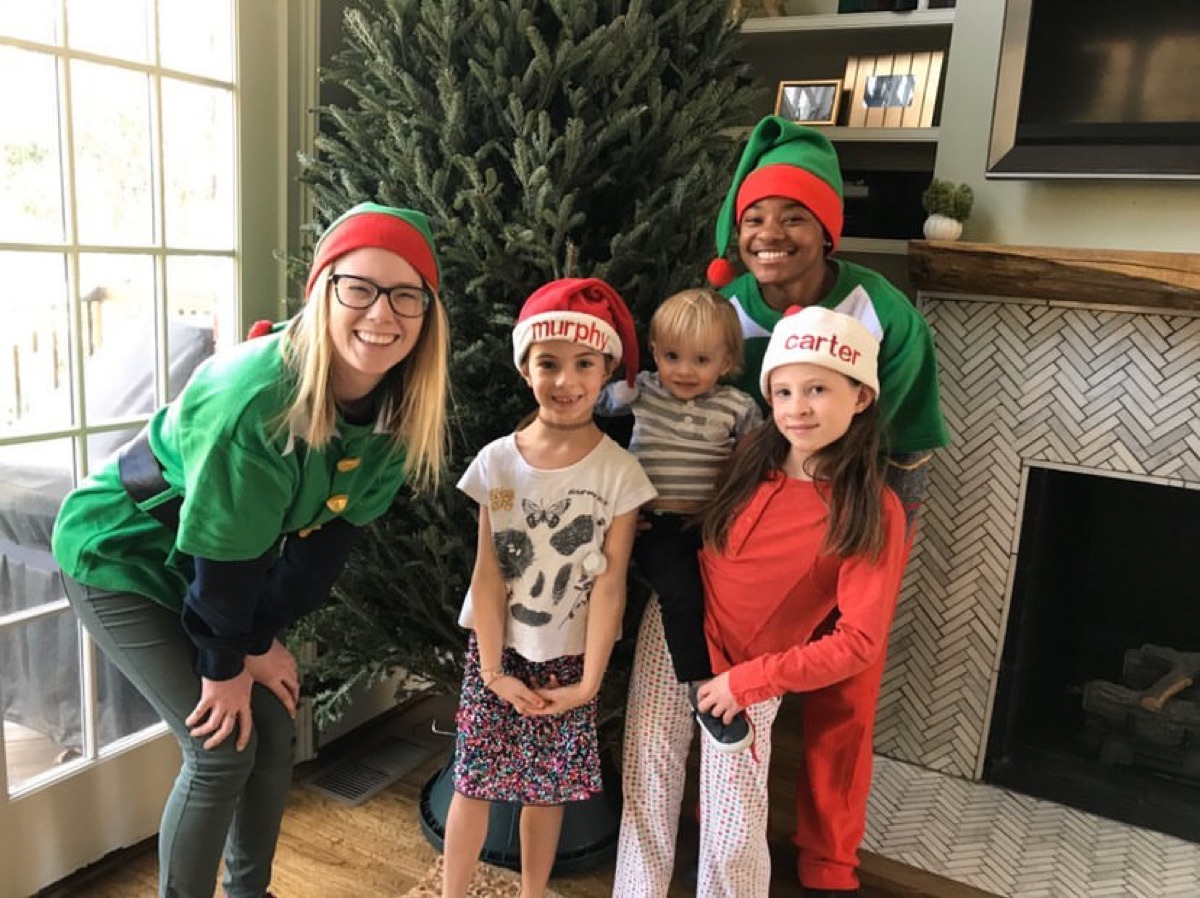 A full Fraser fir in a living room with the elves and three kids