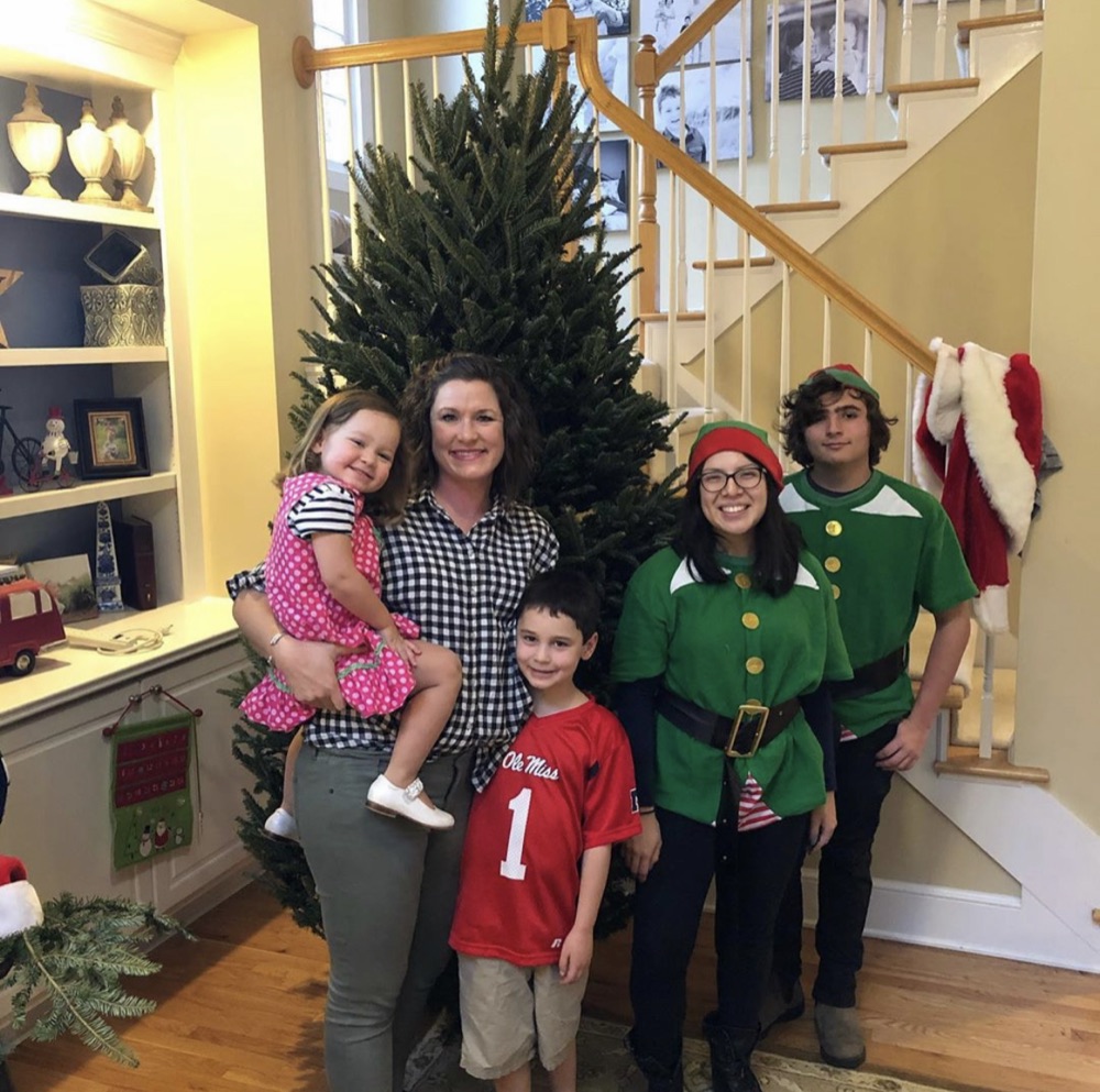 A Fraser fir at the foot of a staircase, with the elves and a family